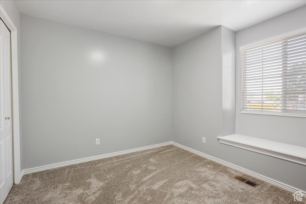 Carpeted empty room with baseboards