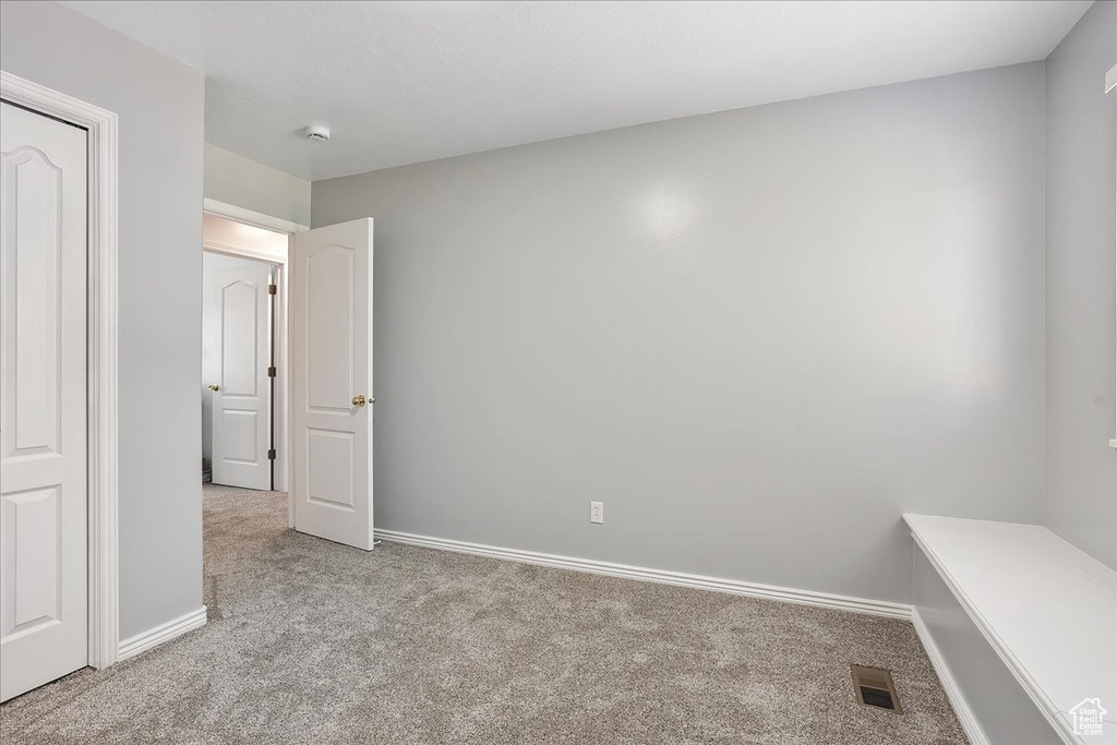 Unfurnished bedroom with carpet flooring and baseboards