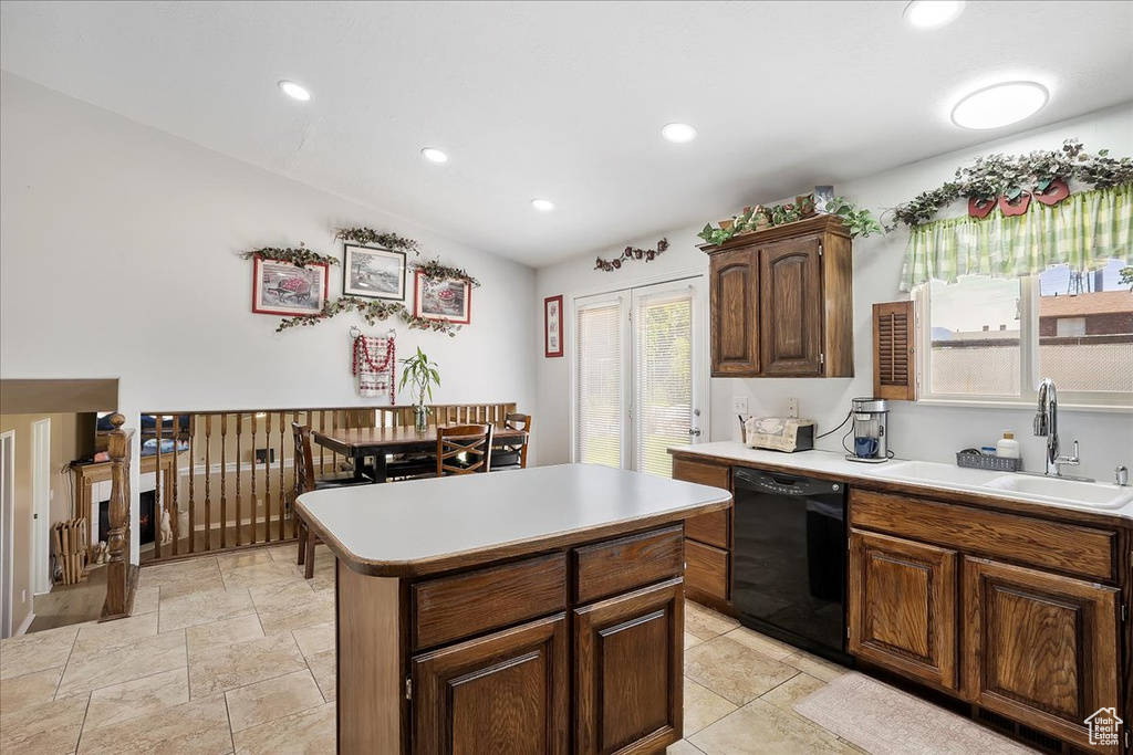 Kitchen with black dishwasher, a sink, light countertops, recessed lighting, and a center island