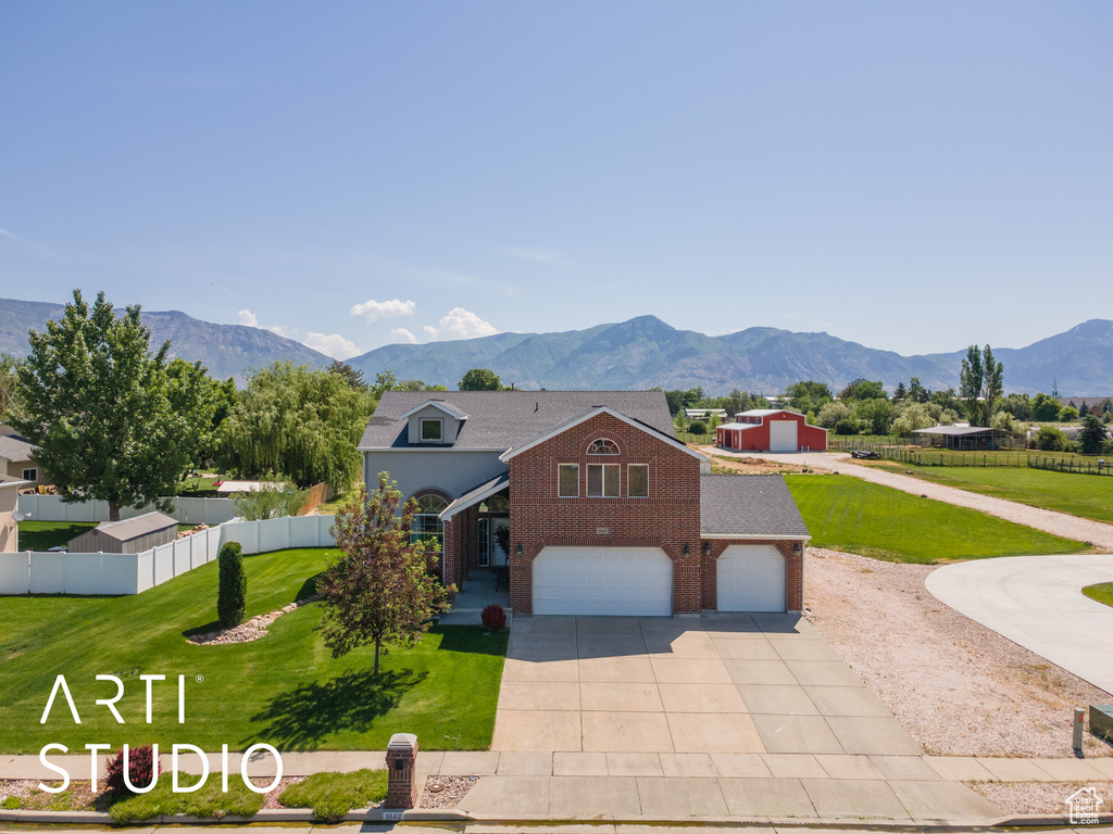 View of front facade featuring brick siding, concrete driveway, a garage, and a mountain view