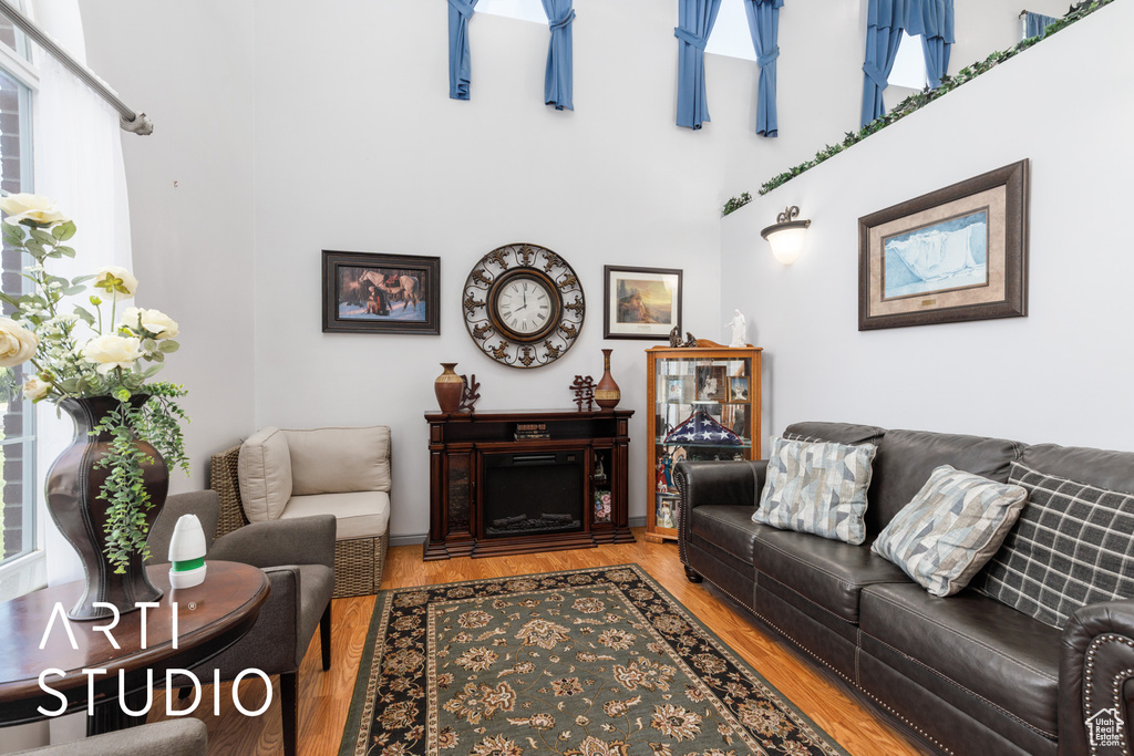 Living area with wood finished floors and a towering ceiling