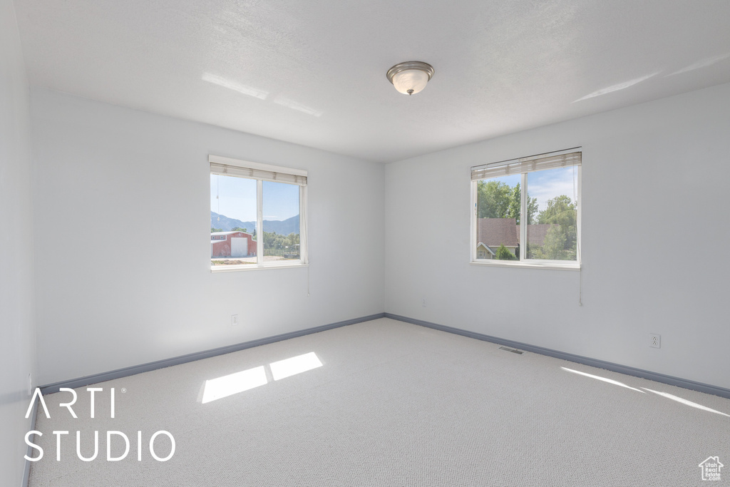 Empty room featuring baseboards and carpet flooring