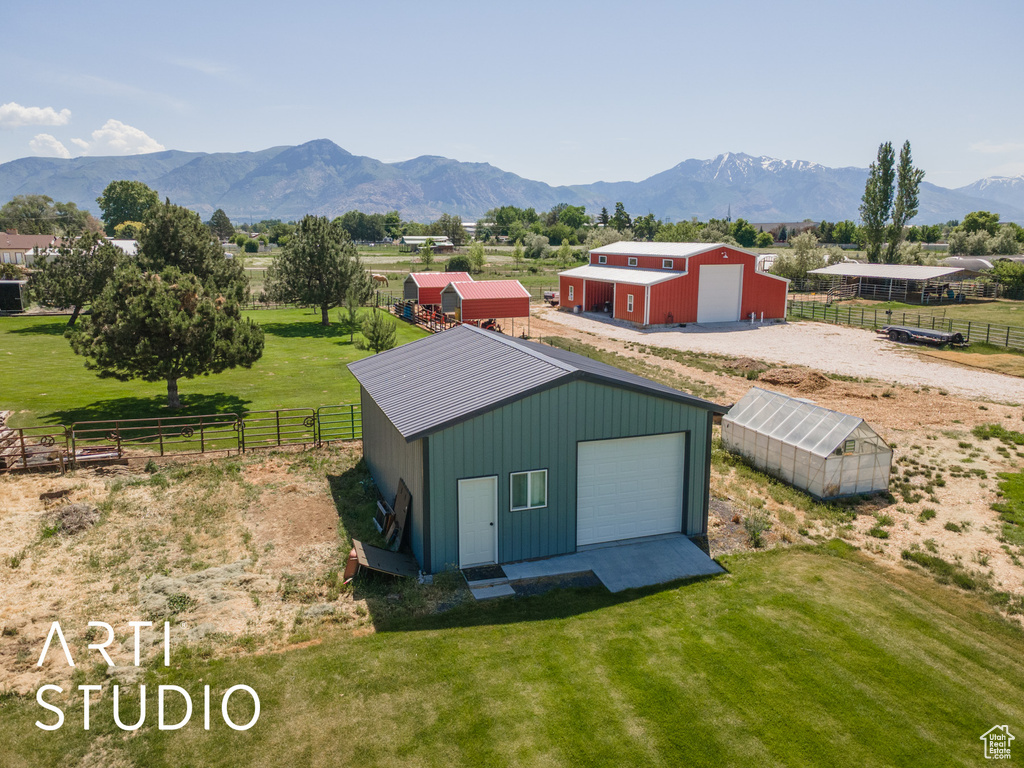 View of pole building featuring a mountain view, an exterior structure, and a view of rural / pastoral area