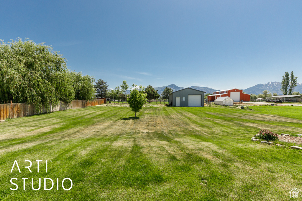 View of yard with an outbuilding, a mountain view, and a detached garage