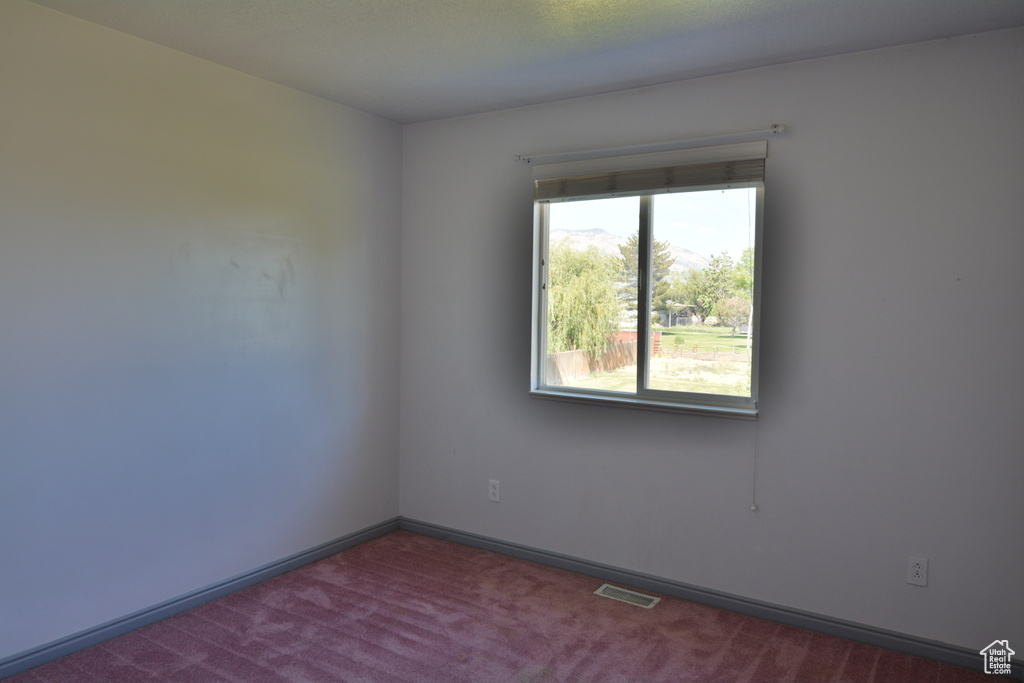 Carpeted spare room with baseboards