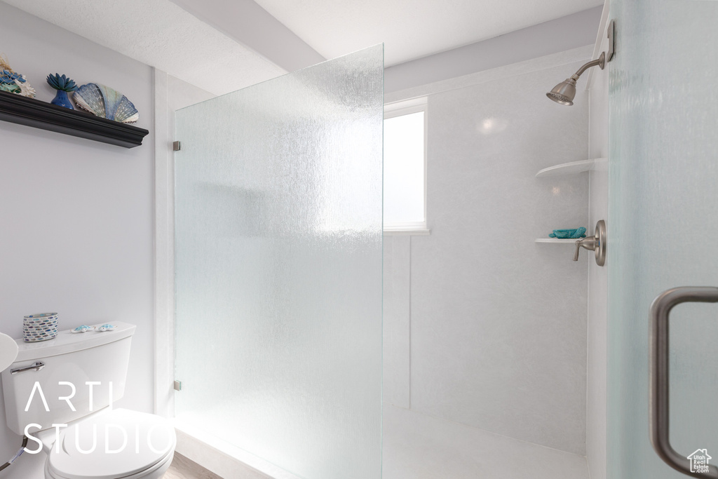 Full bath featuring a shower stall and toilet