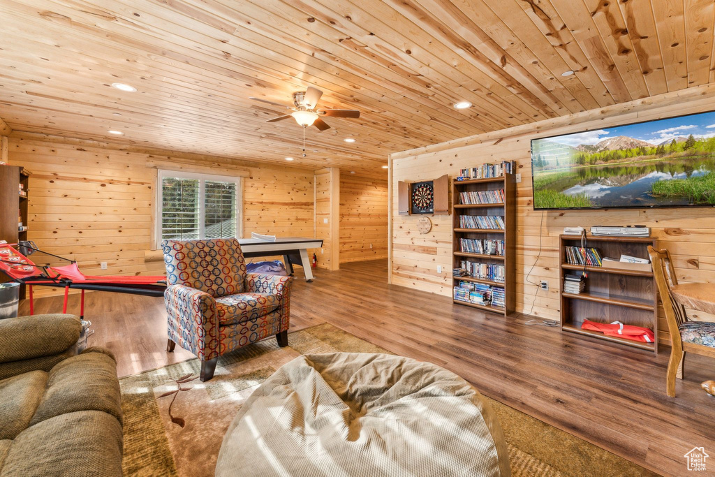 Living area with wooden ceiling, wood finished floors, a ceiling fan, wood walls, and recessed lighting