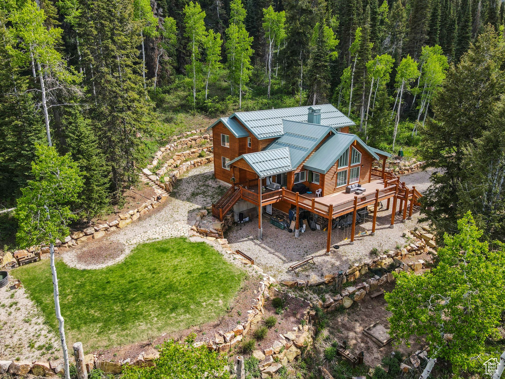 Rear view of house with a deck, a wooded view, metal roof, and stairs