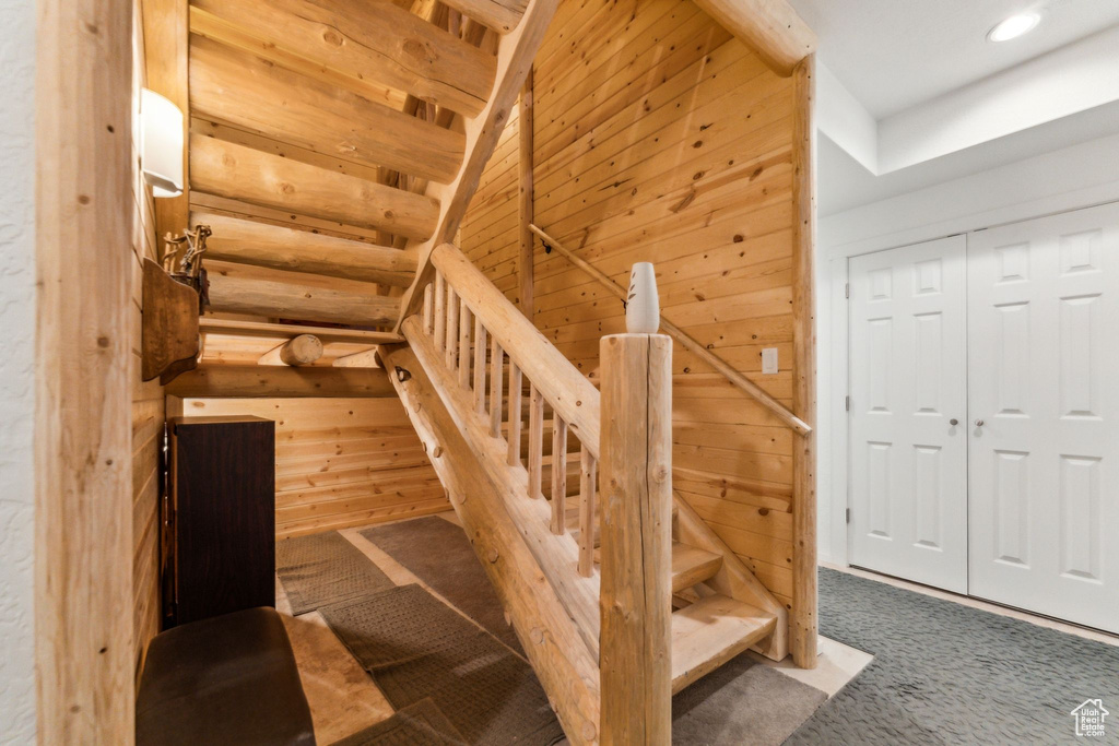Staircase with carpet flooring, wooden walls, and recessed lighting