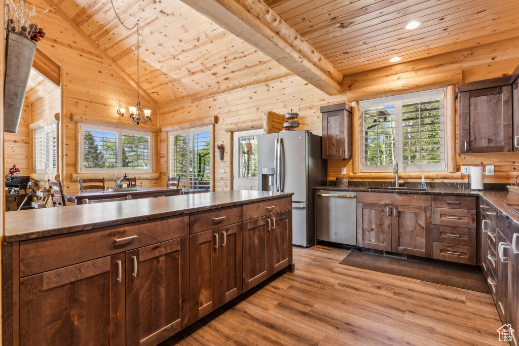 Kitchen with appliances with stainless steel finishes, wooden ceiling, a sink, plenty of natural light, and light wood-style flooring