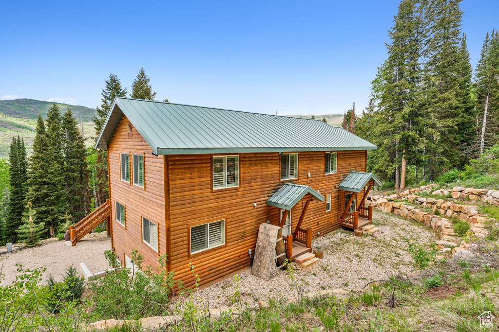 Back of property with metal roof and a mountain view
