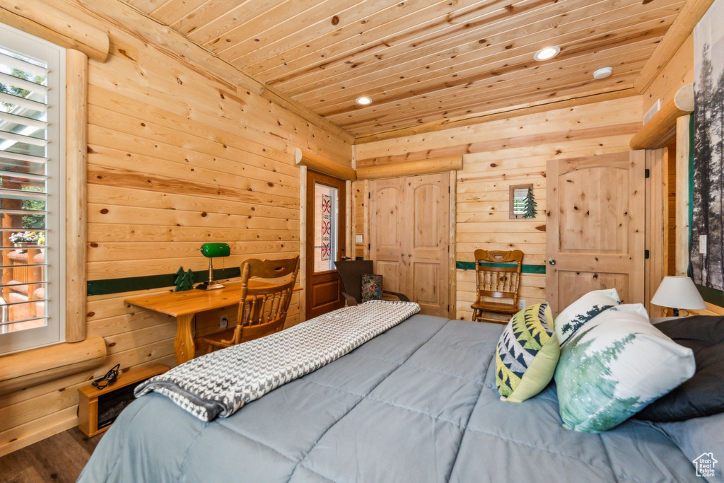 Bedroom with wooden ceiling, wooden walls, and recessed lighting