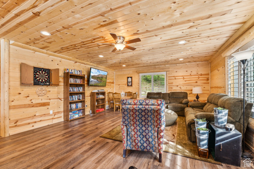 Living area with wooden ceiling, wood finished floors, recessed lighting, ceiling fan, and wood walls