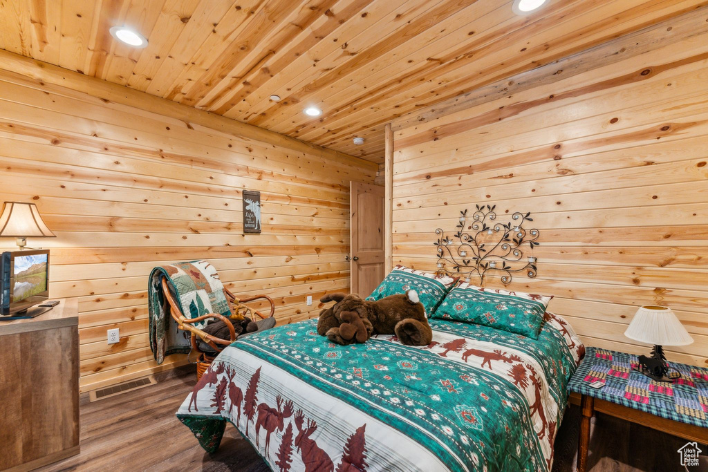 Bedroom with recessed lighting, wood ceiling, wood finished floors, and wooden walls