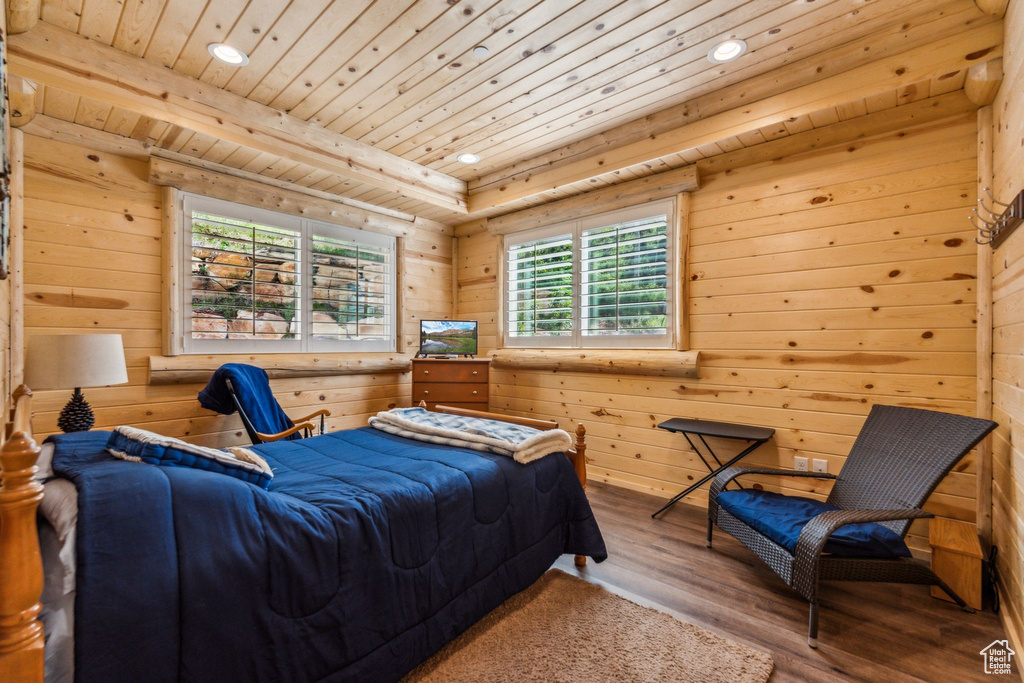Bedroom with multiple windows, recessed lighting, wood finished floors, wood walls, and wooden ceiling