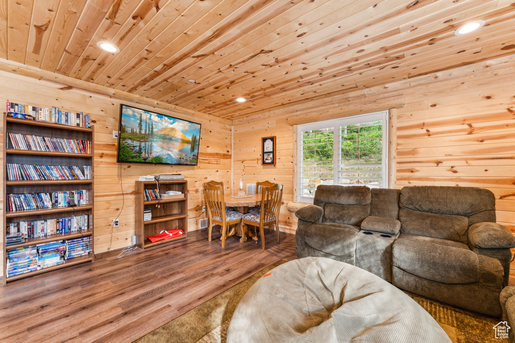 Living room with wooden ceiling, recessed lighting, wood finished floors, and wood walls