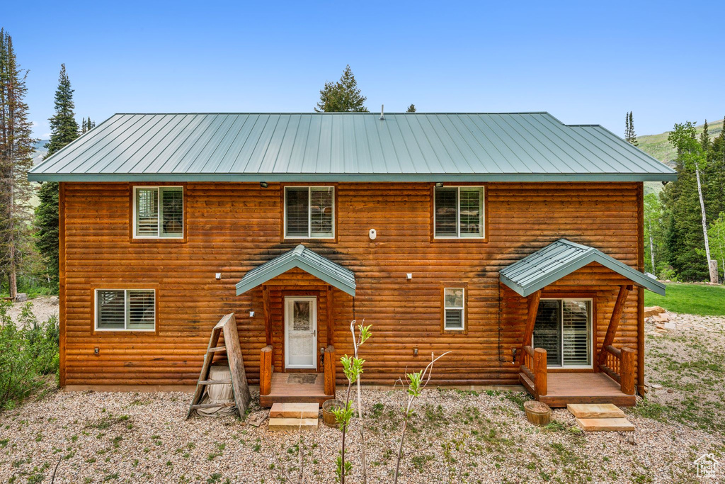 View of front of house featuring metal roof and log veneer siding