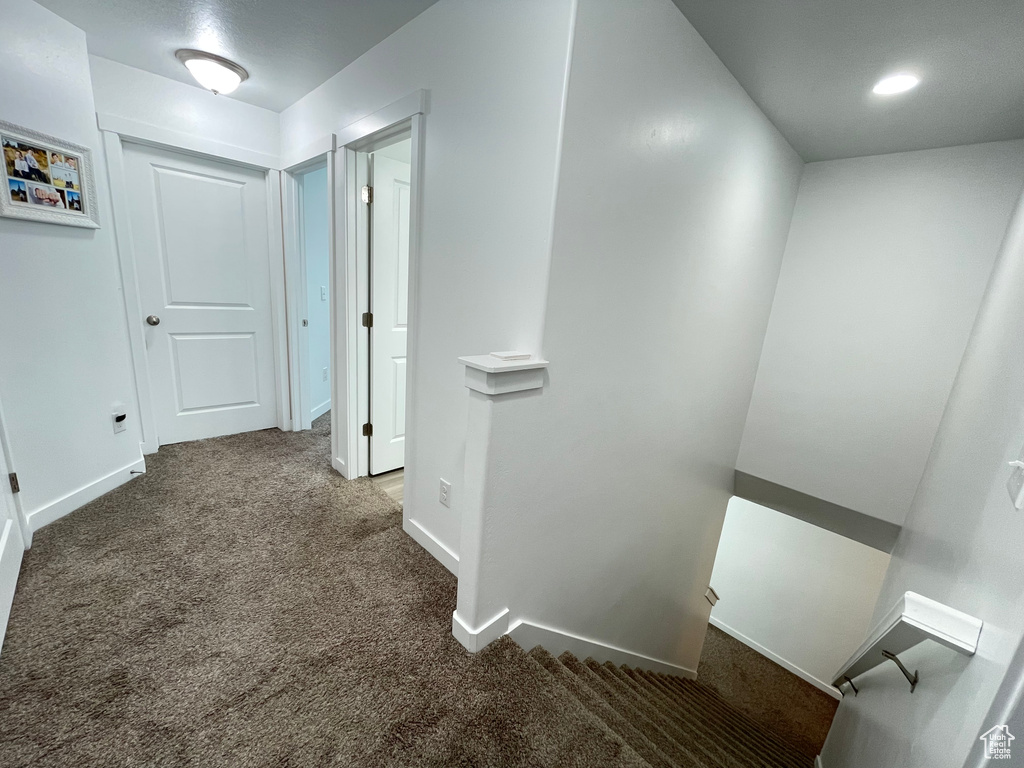 Corridor featuring an upstairs landing, carpet floors, baseboards, and recessed lighting