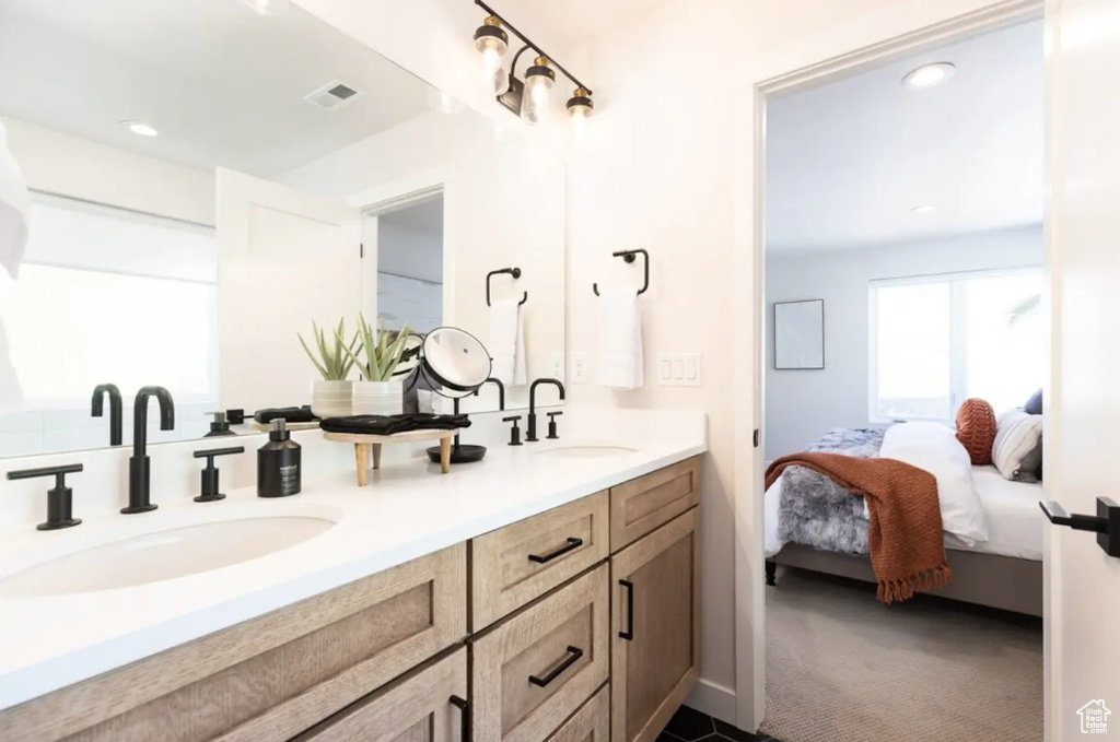 Full bathroom with double vanity, connected bathroom, and recessed lighting