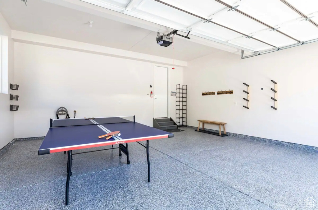 Game room with speckle patterned floor, baseboards, and a garage