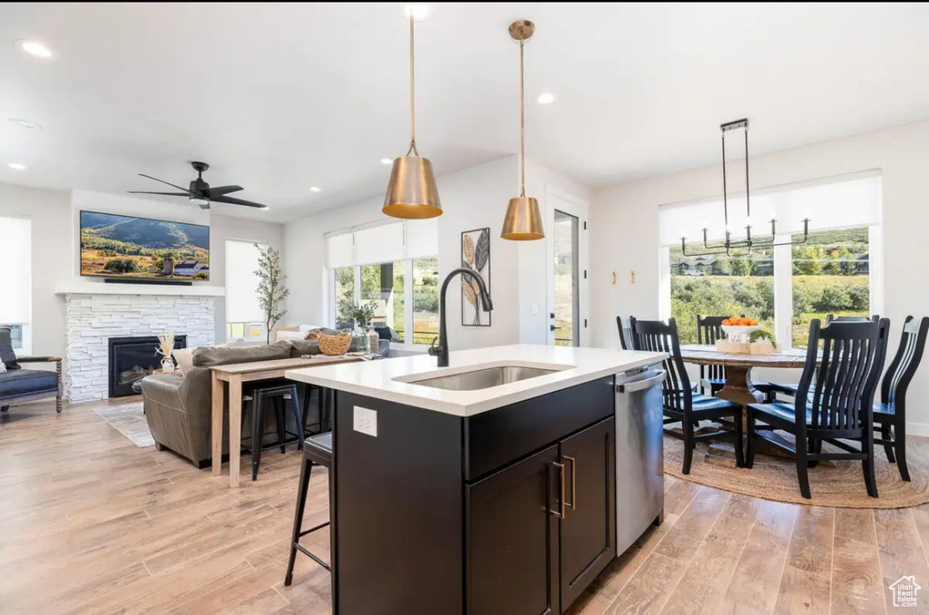 Kitchen featuring a sink, ceiling fan, light wood-style floors, light countertops, and stainless steel dishwasher