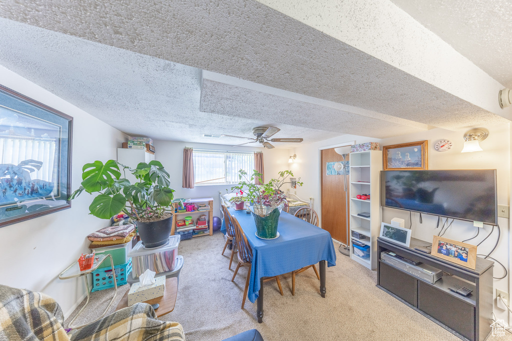 Dining room featuring a textured ceiling, carpet, and ceiling fan