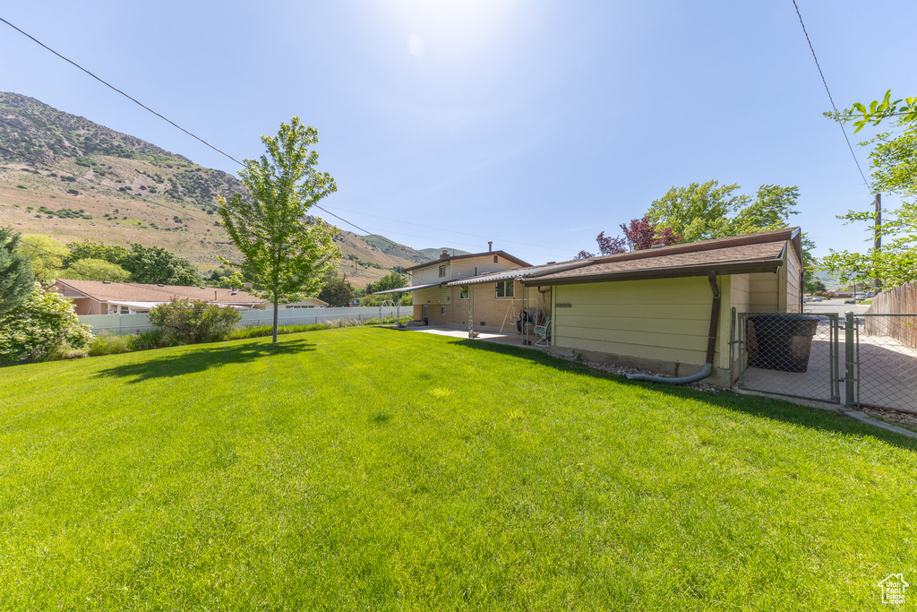 View of yard with a gate, a mountain view, and a patio area