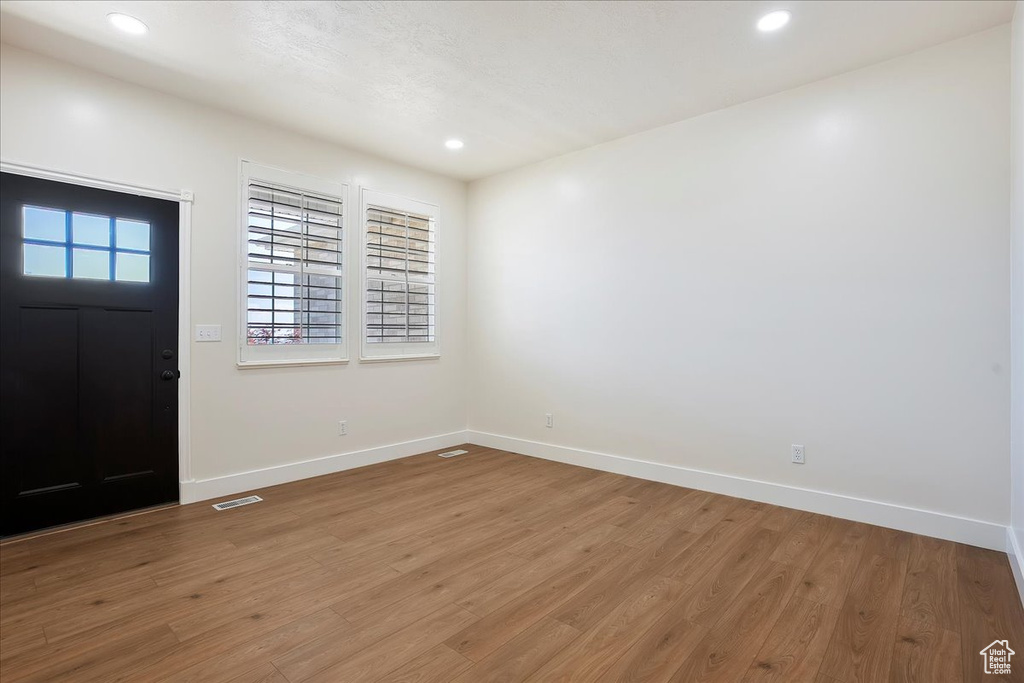 Foyer entrance featuring baseboards, wood finished floors, and recessed lighting