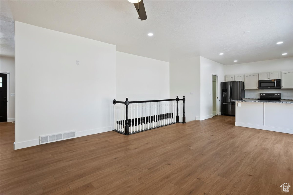 Kitchen featuring black appliances, recessed lighting, wood finished floors, baseboards, and ceiling fan