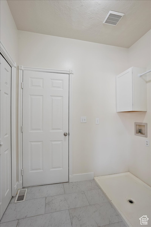 Laundry room with washer hookup, light marble finish flooring, baseboards, and cabinet space