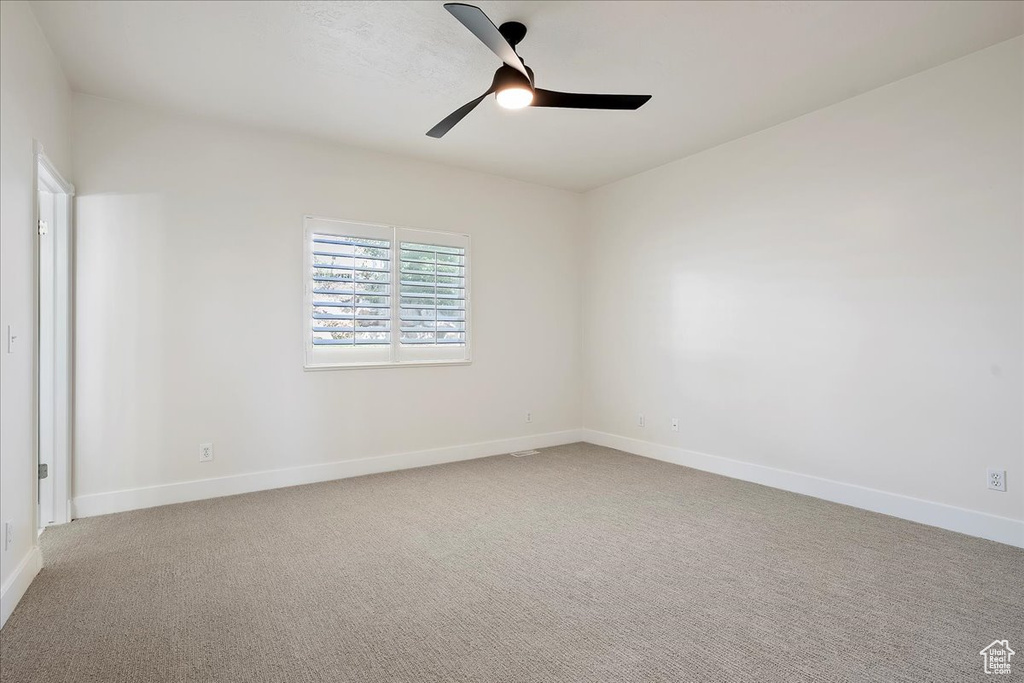 Unfurnished room featuring a ceiling fan, baseboards, and carpet flooring