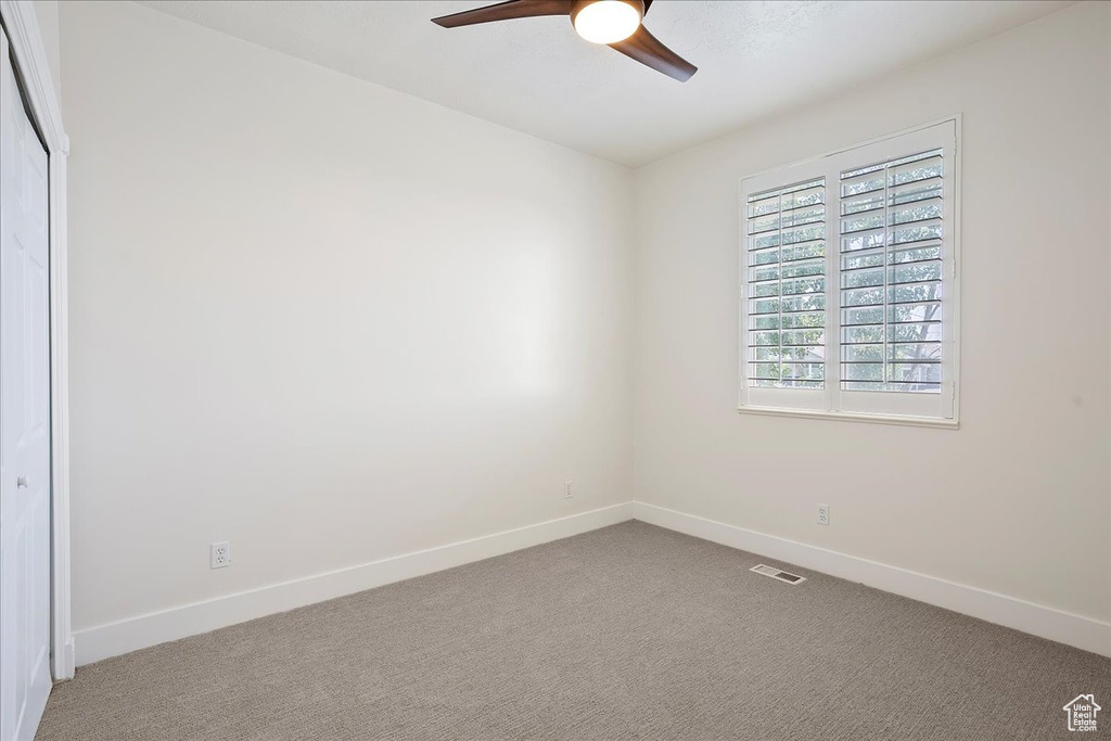Unfurnished room featuring a ceiling fan, baseboards, and carpet flooring