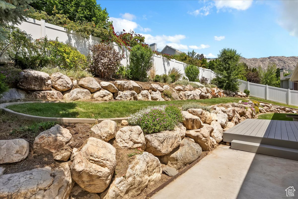 Fenced backyard with a deck with mountain view