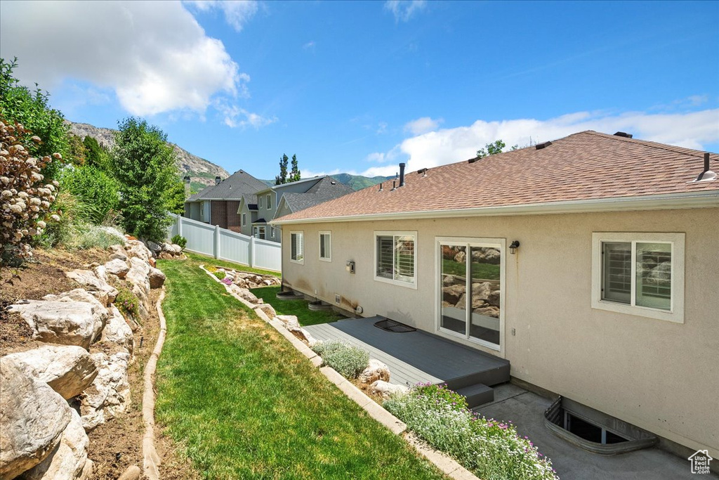 Rear view of property with stucco siding and a shingled roof
