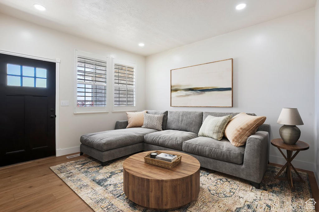 Living room featuring wood finished floors, baseboards, and recessed lighting