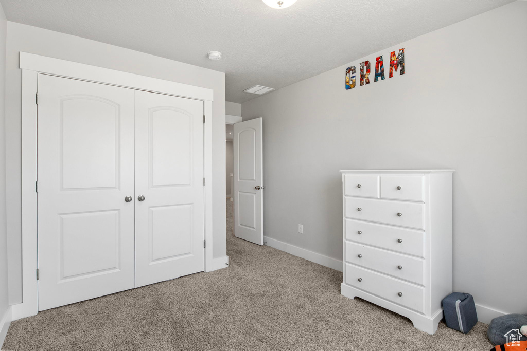 Carpeted bedroom featuring baseboards and a closet