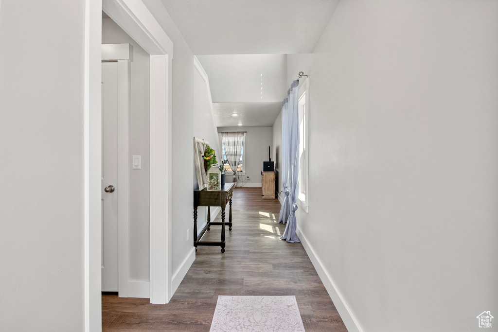 Hall featuring dark wood finished floors and baseboards