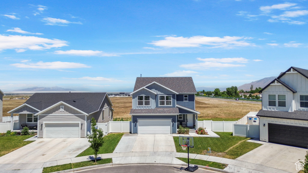 Traditional-style house featuring a mountain view, concrete driveway, and a garage