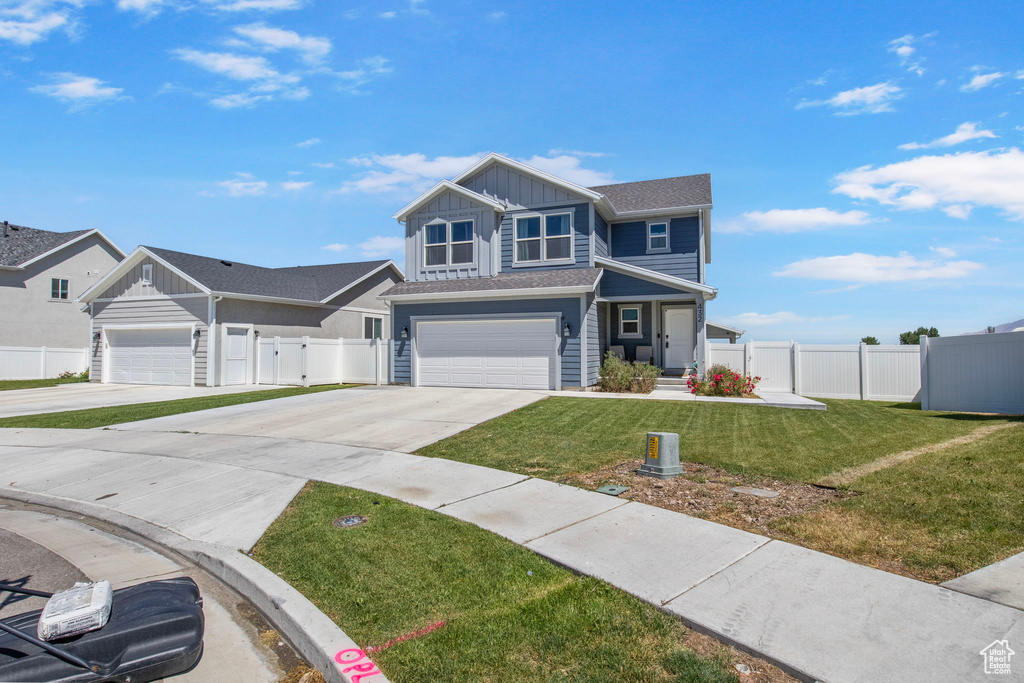 View of front of property featuring board and batten siding, concrete driveway, a garage, and a shingled roof