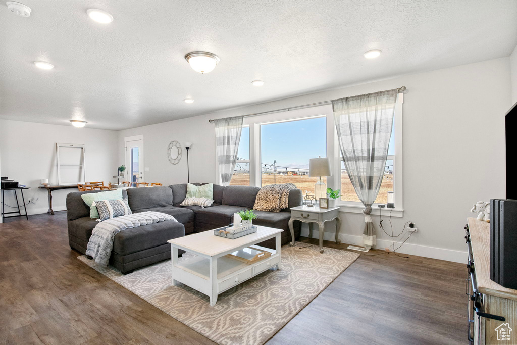 Living room with wood finished floors, baseboards, and recessed lighting