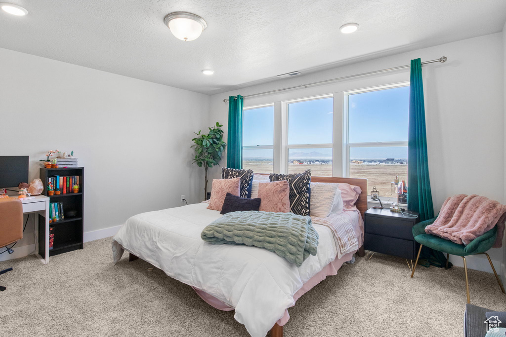 Carpeted bedroom with a water view, baseboards, and recessed lighting