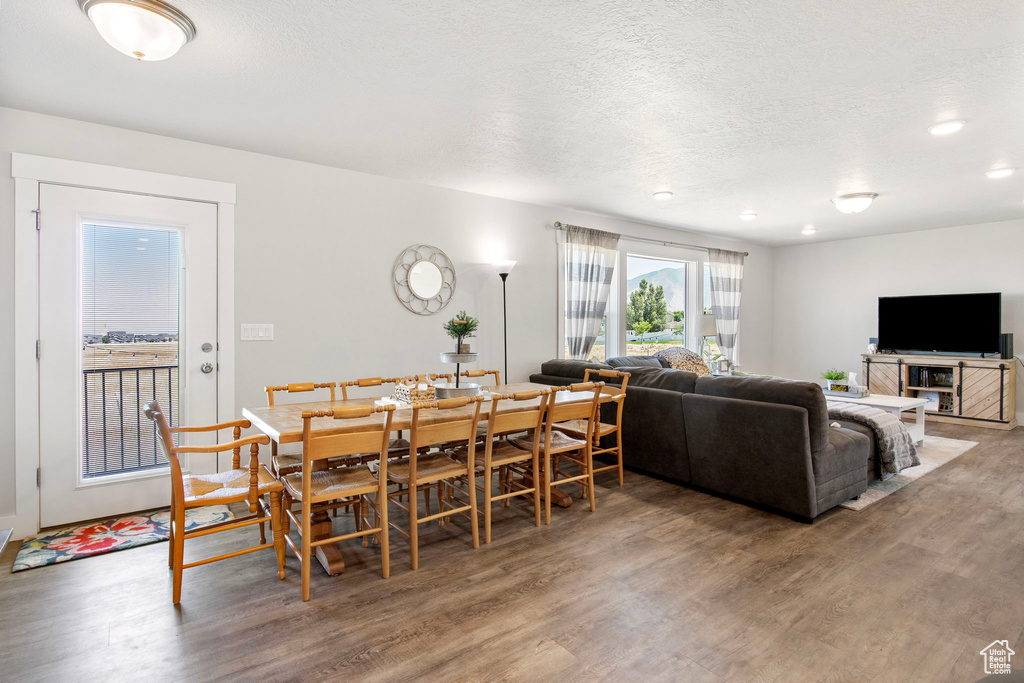 Dining area featuring light wood-style floors and a textured ceiling