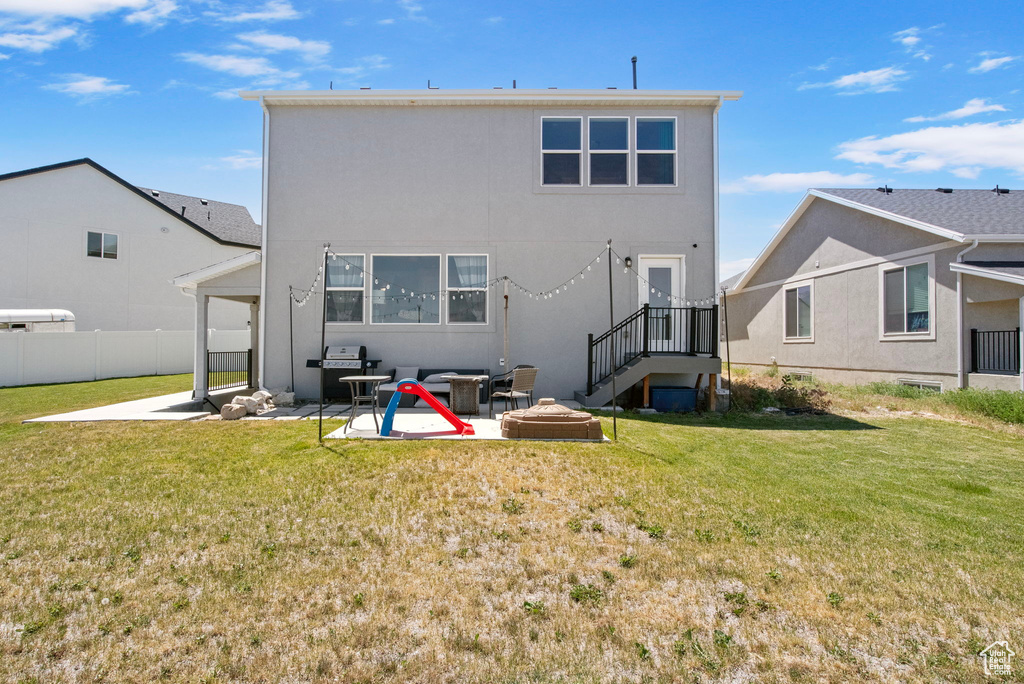 Back of property with a patio, a fire pit, and stucco siding