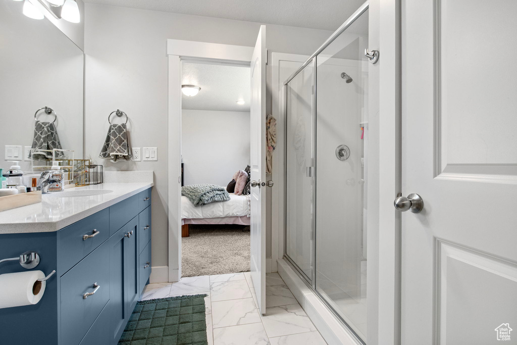 Bathroom with vanity, marble finish flooring, a stall shower, and ensuite bath