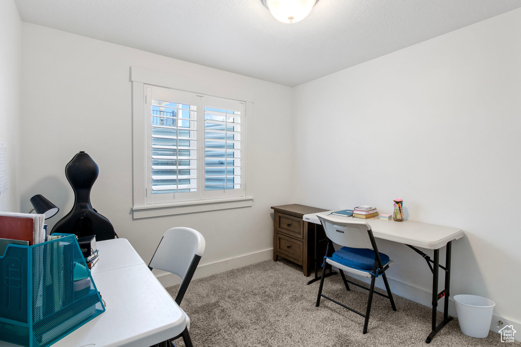 Office with light colored carpet and baseboards