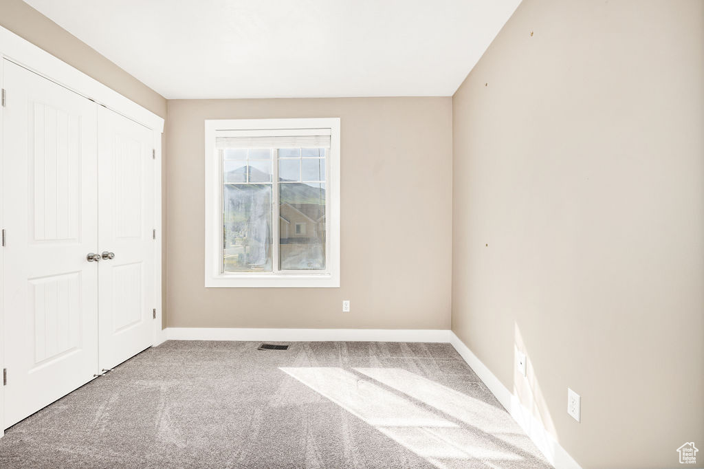 Unfurnished bedroom featuring baseboards, carpet floors, and a closet