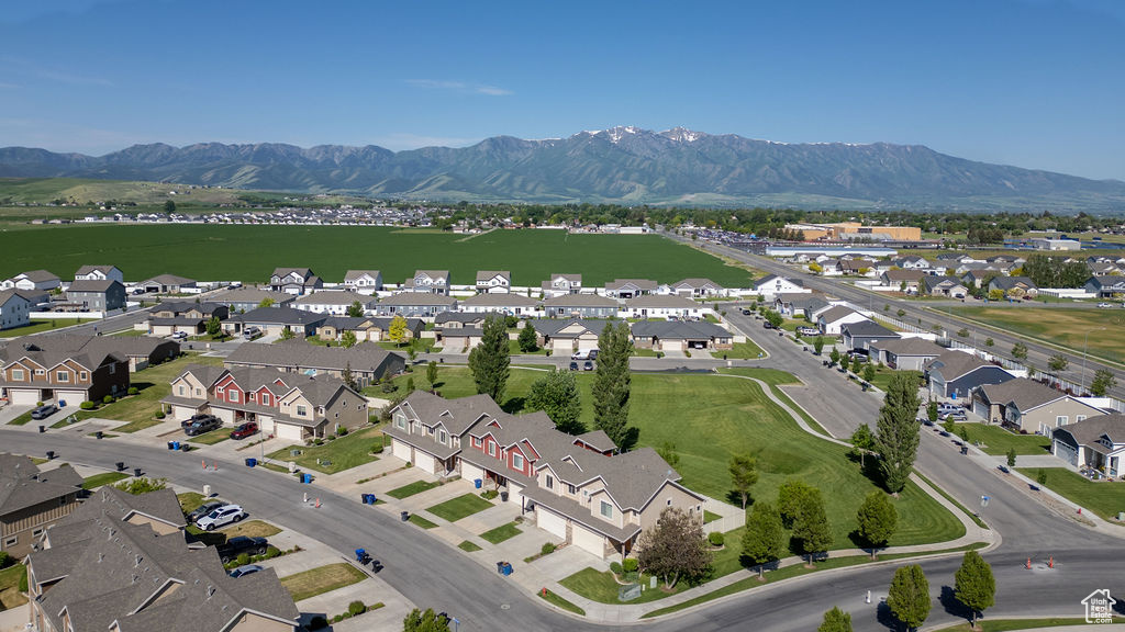 Aerial view of property and surrounding area with mountains and nearby suburban area