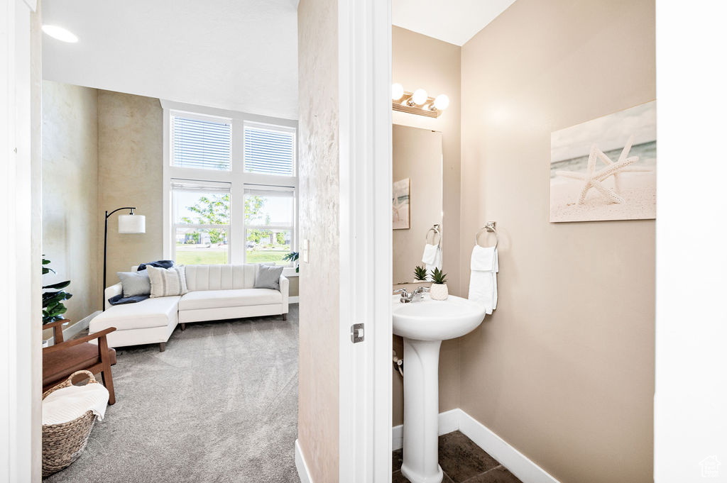 Bathroom featuring baseboards, a sink, and ensuite bathroom