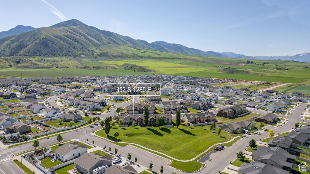 Aerial view of property and surrounding area featuring nearby suburban area and mountains