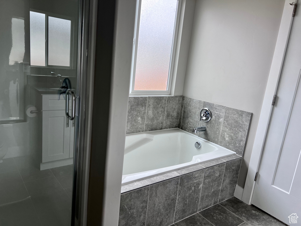 Full bathroom with tile patterned floors and a garden tub